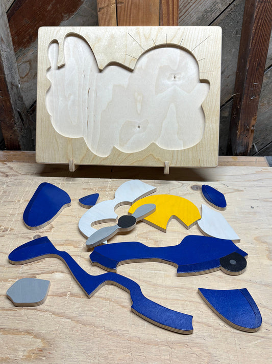 Wooden pieces of airplane puzzle shapes on a wooden surface