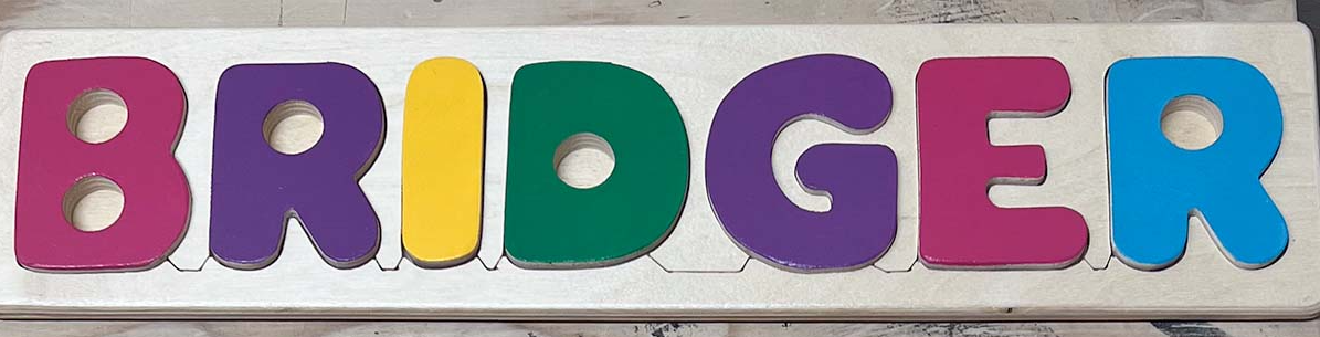 Colorful wooden letters spelling 'BRIDGER' on a white background