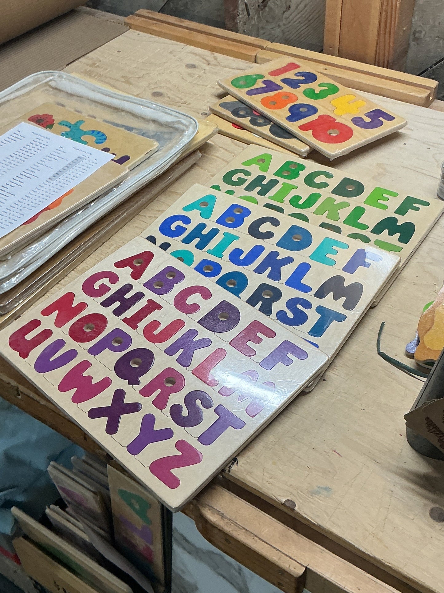 Colorful alphabet puzzle on a wooden surface with various items around