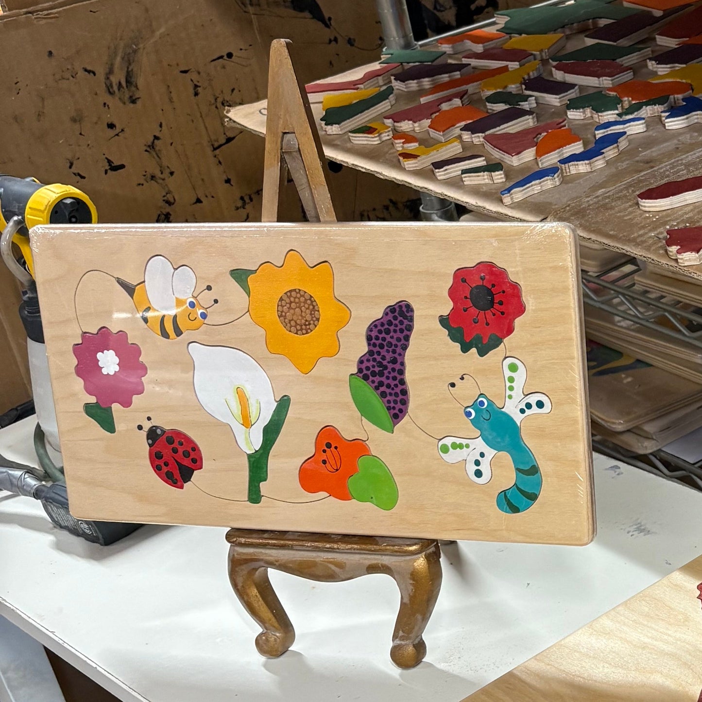 Colorful artwork on easel in a workshop setting.