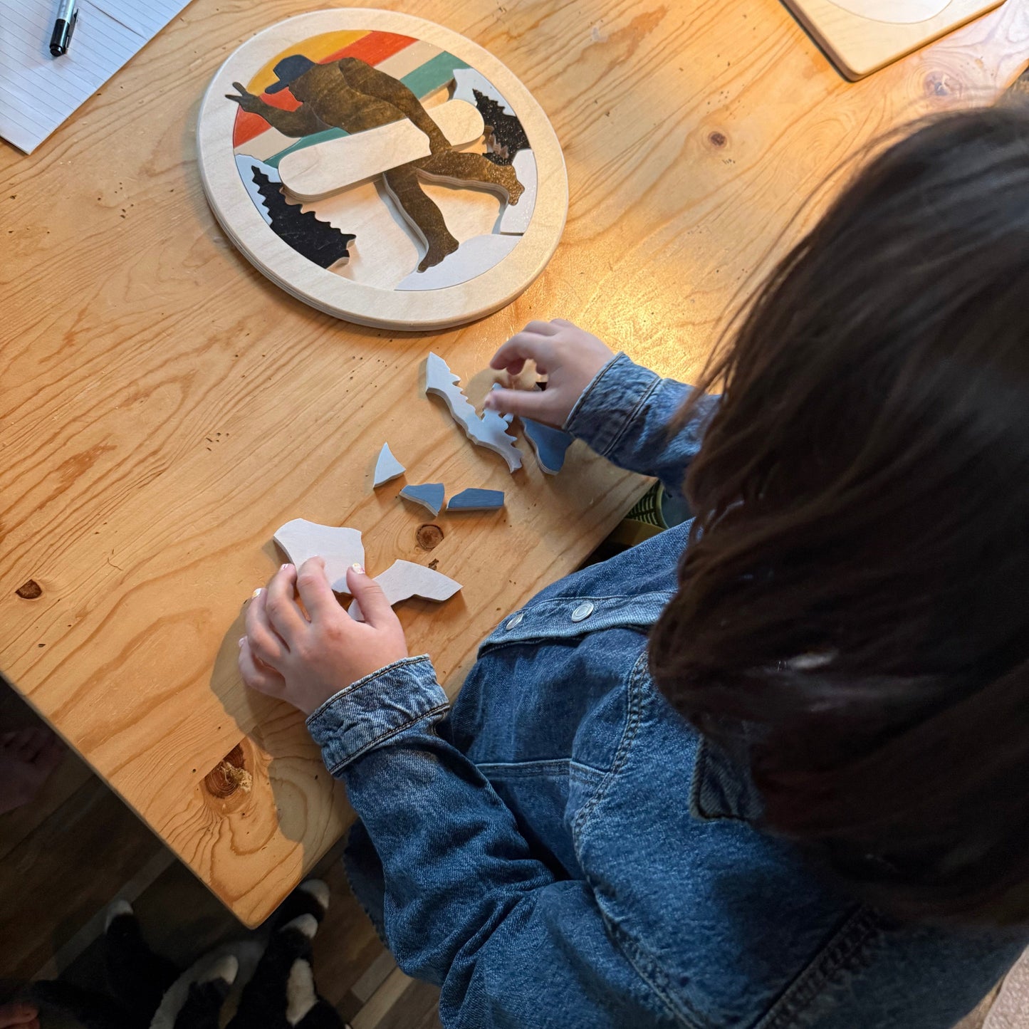 Child working on a puzzle at a wooden table
