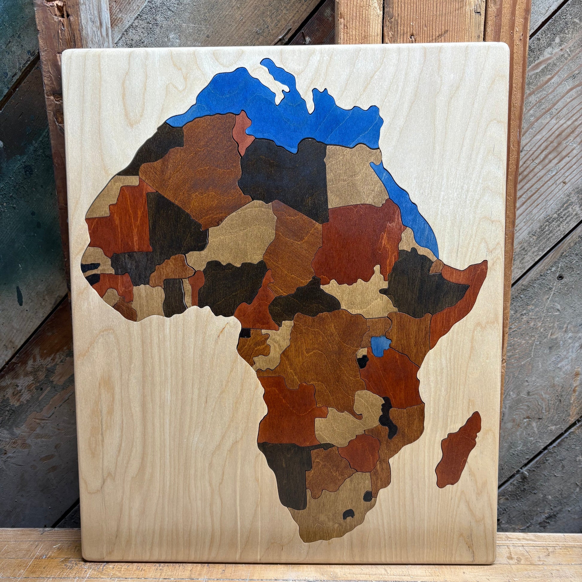 Wooden map of African Continent with a blue ocean on a rustic wooden surface