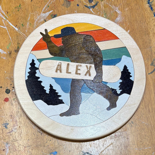 Round puzzle with 'ALEX' design on a wooden surface